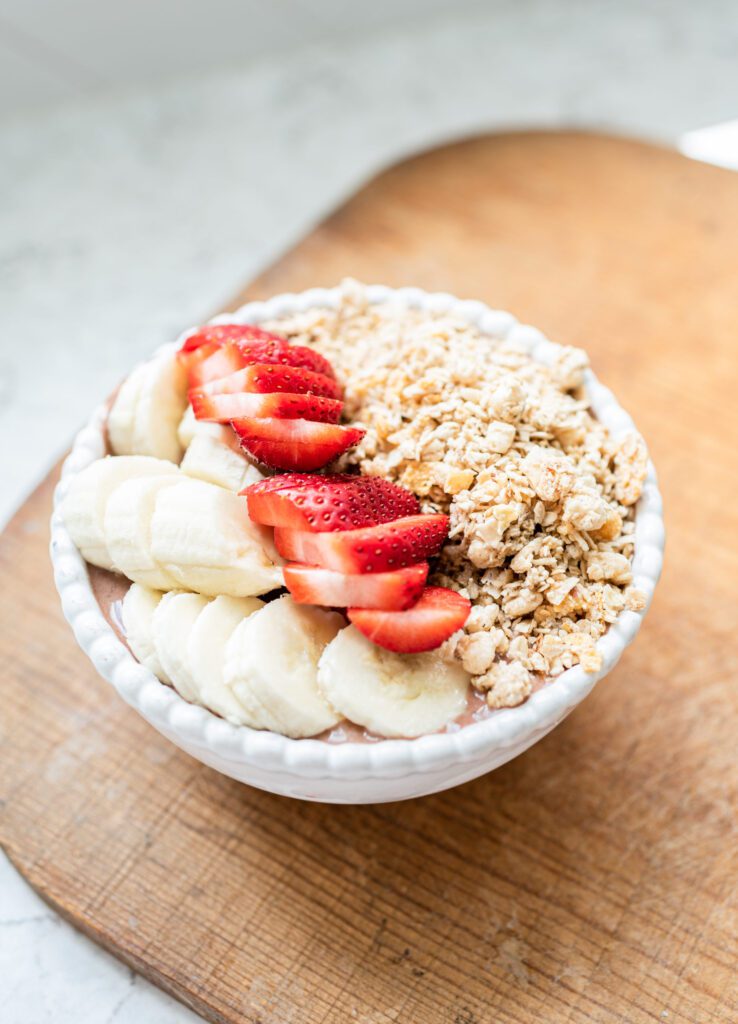 Colorful smoothie bowl with blended oats and strawberries, garnished with fresh fruit and served in an elegant dish for a nutritious breakfast option.