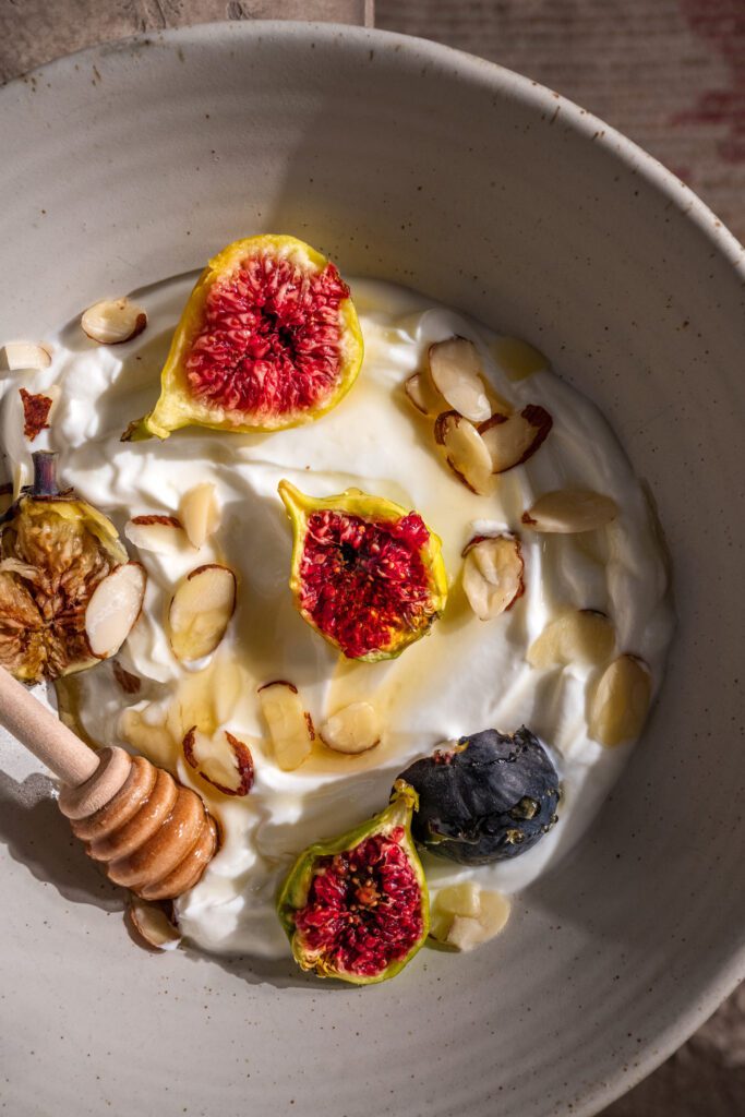 A bowl of Greek yogurt topped with fresh fruit, nuts, and honey, a healthy breakfast option
